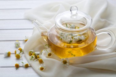 Bir fincan papatya çayı ve papatya çiçeği..