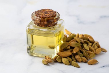 Yeşil kakule, cam kaplarda gerekli yağ ve kakule kapsülleri.