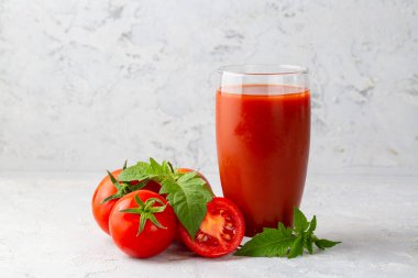 Tomato juice in a glass and fresh tomatoes