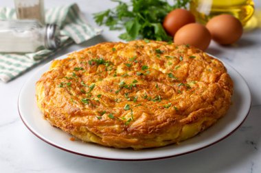 Spanish omelette with potatoes, typical spanish cuisine on gray concrete floor. Tortilla Espanola. Turkish name; Yumurtali patates