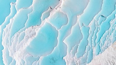 Gökyüzü manzaralı Pamukkale Türkiye travertin havuzları, mavi suyla birlikte doğa terasları.