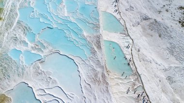 Gökyüzü manzaralı Pamukkale Türkiye travertin havuzları, mavi suyla birlikte doğa terasları.