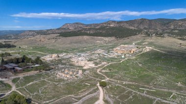 Türkiye 'nin Pamukkale kentindeki pitoresk bir vadide antik harabelerin ve manzaralı dağların havadan görünüşü.