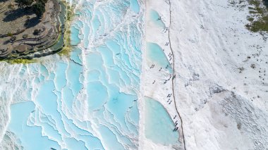 Gökyüzü manzaralı Pamukkale Türkiye travertin havuzları, mavi suyla birlikte doğa terasları.