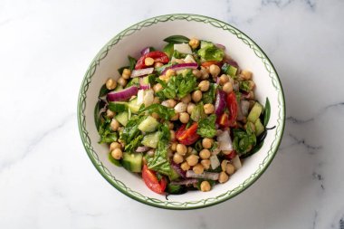 Domates, roka, maydanoz, ıspanak ve kırmızı soğanlı vejetaryen nohut salatası. Sağlıklı yiyecekler, diyet. Üst görünüm