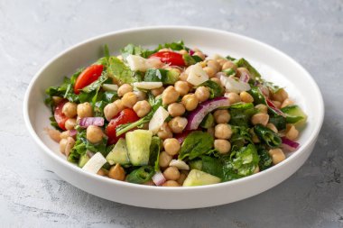 Domates, roka, maydanoz, ıspanak ve kırmızı soğanlı vejetaryen nohut salatası. Sağlıklı yiyecekler, diyet. Üst görünüm