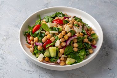 Domates, roka, maydanoz, ıspanak ve kırmızı soğanlı vejetaryen nohut salatası. Sağlıklı yiyecekler, diyet. Üst görünüm