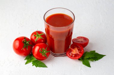 Tomato juice in a glass and fresh tomatoes