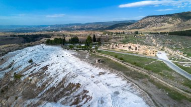 Gökyüzü manzaralı Pamukkale Türkiye travertin havuzları, mavi suyla birlikte doğa terasları.