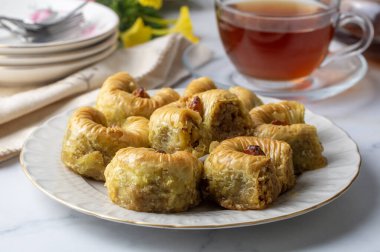 Geleneksel Türk tatlısının adı Bulbul Yuvasi, içinde ceviz bulunan özel baklava ve üzerinde şam fıstığı tozu olan Şerbet tatlısı, Türkçe adı 'Bulbul Yuvasi'.