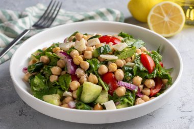 Domates, roka, maydanoz, ıspanak ve kırmızı soğanlı vejetaryen nohut salatası. Sağlıklı yiyecekler, diyet. Üst görünüm