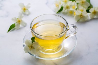 Bir bardak aromatik yasemin çayı ve taze çiçekler.