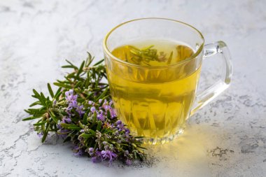 Taze biberiyeli bir fincan sağlıklı biberiye çayı. Kırsal arka planda, kış bitkisi sıcak içecek konsepti, salvia rosmarinus.