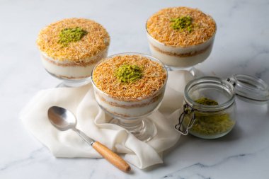 Geleneksel bir süt bazlı Ramazan tatlısı: kızarmış kadayf (dilimlenmiş fillo hamuru) ve dilimlenmiş şam fıstıklı muhallebi. Kadaif Muhallebi