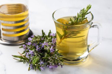 Taze biberiyeli bir fincan sağlıklı biberiye çayı. Kırsal arka planda, kış bitkisi sıcak içecek konsepti, salvia rosmarinus.