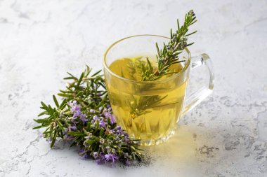 Taze biberiyeli bir fincan sağlıklı biberiye çayı. Kırsal arka planda, kış bitkisi sıcak içecek konsepti, salvia rosmarinus.