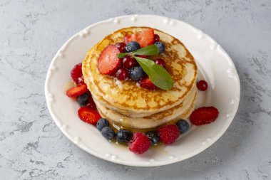 Sağlıklı yaz kahvaltısı, taze meyve ve ballı ev yapımı Amerikan krepleri.