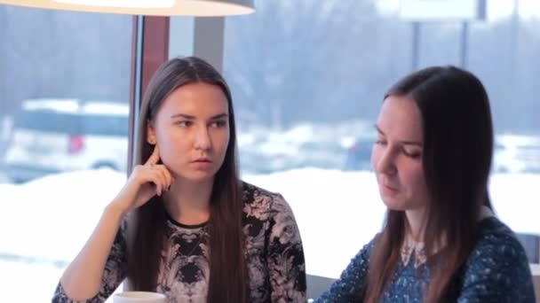 Duas namoradas sorridentes bebem café e se comunicam — Vídeo de Stock