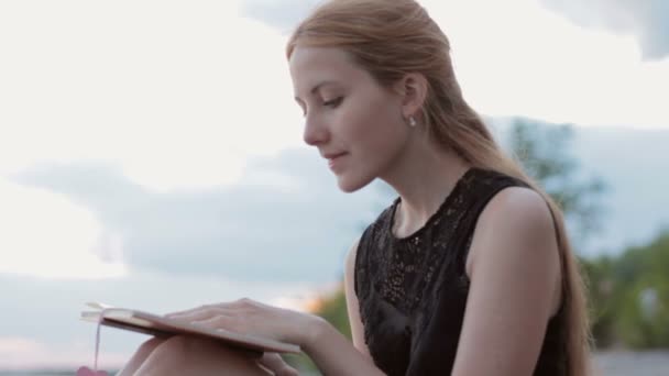 Linda chica leyendo libro al aire libre — Vídeos de Stock