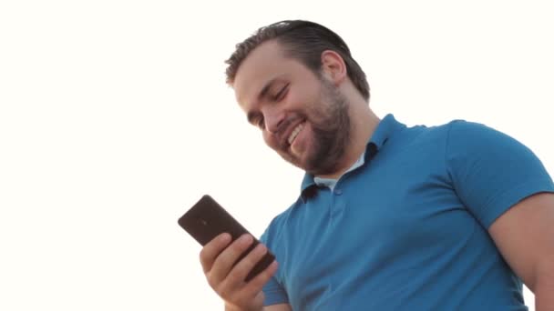 Faible perspective de sourire homme adulte en utilisant un téléphone portable — Video