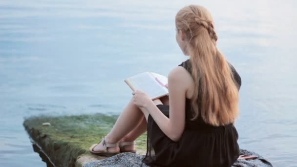 Linda chica leyendo libro al aire libre — Vídeos de Stock