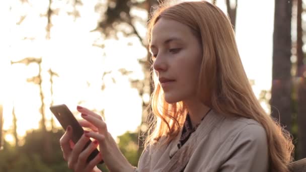 Seitenansicht eines rothaarigen Mädchens mit Mobiltelefon — Stockvideo