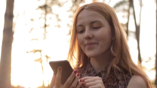 Fille rire tout en utilisant le téléphone mobile dans la campagne — Video