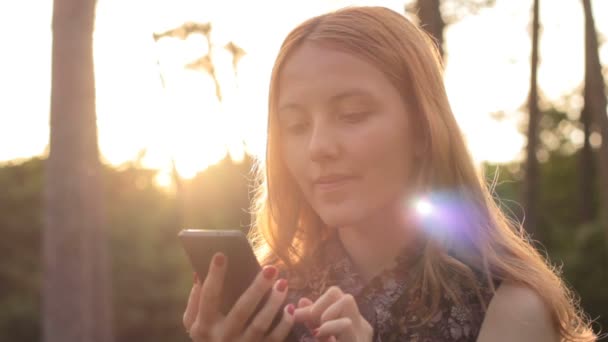 Rudowłosa dziewczyna przy użyciu telefonu komórkowego — Wideo stockowe