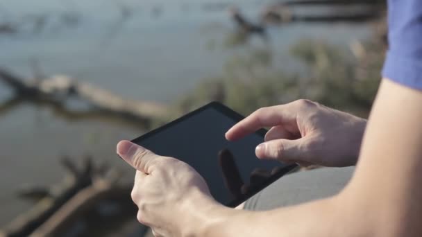 Jovem trabalhando ao ar livre com tablet . — Vídeo de Stock