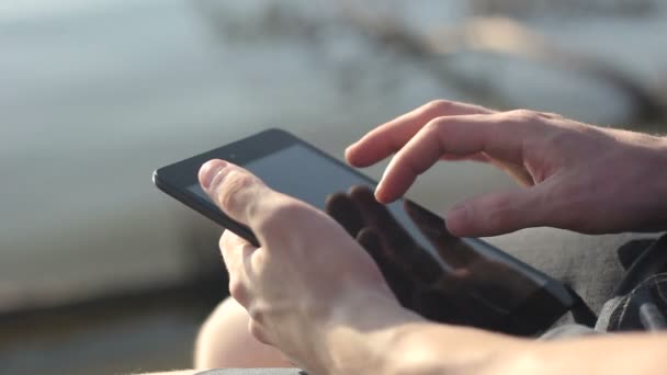Jovem trabalhando ao ar livre com tablet . — Vídeo de Stock