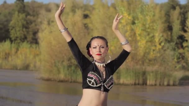Hermosa chica bailando danza exótica en la naturaleza — Vídeo de stock