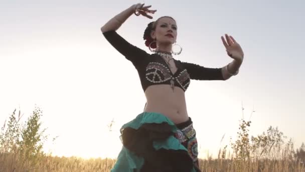 Девушка прекрасно танцует танец живота на природе — стоковое видео