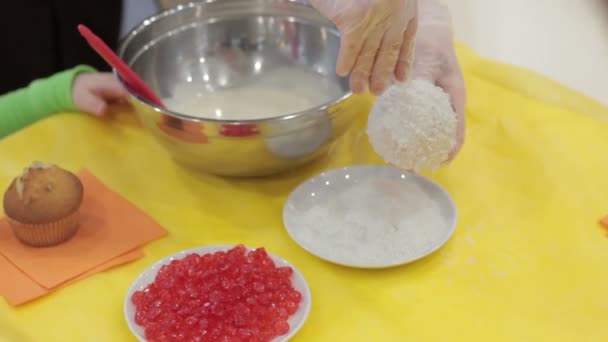 Woman coconut sprinkles on a muffin — Stock Video