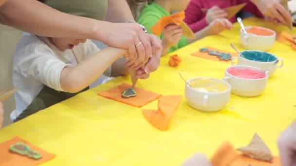 Kleines glückliches Mädchen dekoriert Lebkuchen — Stockvideo