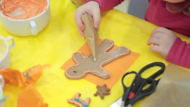 Närbild på kid dekorera pepparkakor cookies — Stockvideo