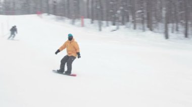 Kış günü dağda erkek snowboard slaytları.