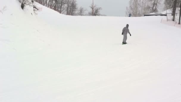 Mannelijke snowboarder dia's in de berg in de winterdag. — Stockvideo