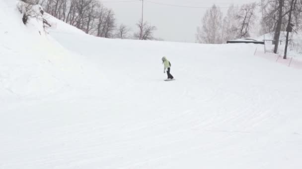 Slides de snowboarder feminino no dia de inverno da montanha — Vídeo de Stock