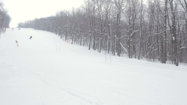 Naaras lumilautailija liukuu vuoren talvipäivänä — kuvapankkivideo