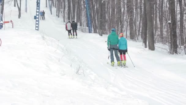 Pareja de esquiadores Remonte en una pista pequeña para esquiar . — Vídeo de stock