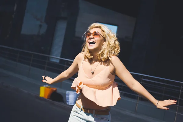Krásná mladá blondýnka pózuje na ulici města — Stock fotografie