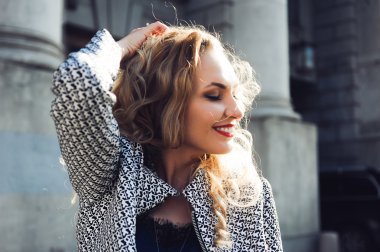 güzel sarışın gülme ve şehrin arka planında poz