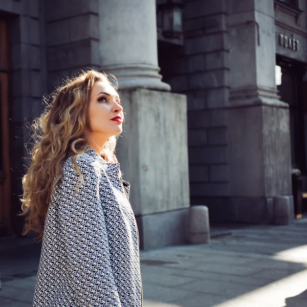 Beautiful blonde laughing and posing against the backdrop of the city — Stock Photo, Image