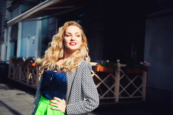 Beautiful blonde laughing and posing against the backdrop of the city — Stock Photo, Image