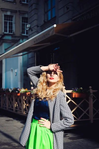 Mooie blonde lachen en poseren tegen de achtergrond van de stad — Stockfoto