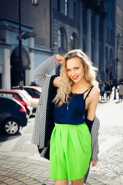 Mooie blonde lachen en poseren tegen de achtergrond van de stad — Stockfoto