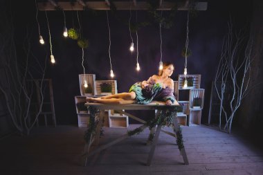 stüdyoda bir kız portresi ahşap bir platform üzerinde yatıyor 