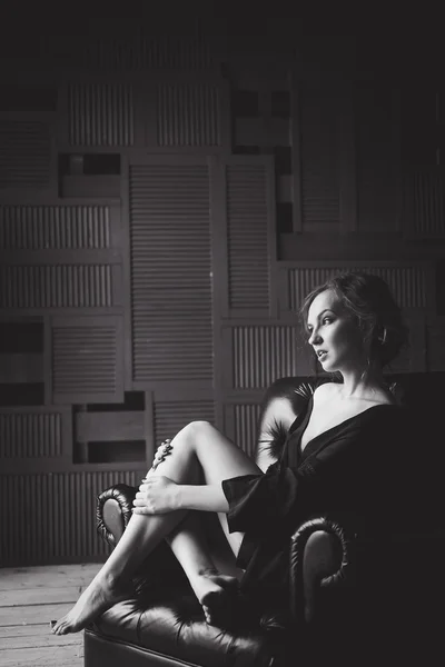 Close-up portrait of a young slim sexy girl in black lingerie sitting on a chair Royalty Free Stock Images