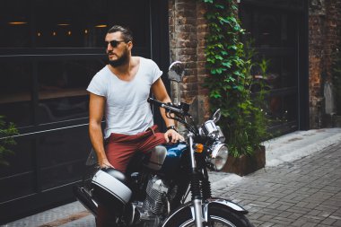 poz motosiklet üzerinde oturan genç adam