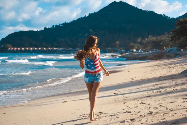 Retrato de una hermosa joven morena con el pelo largo sobre un fondo de mar azul — Foto de Stock